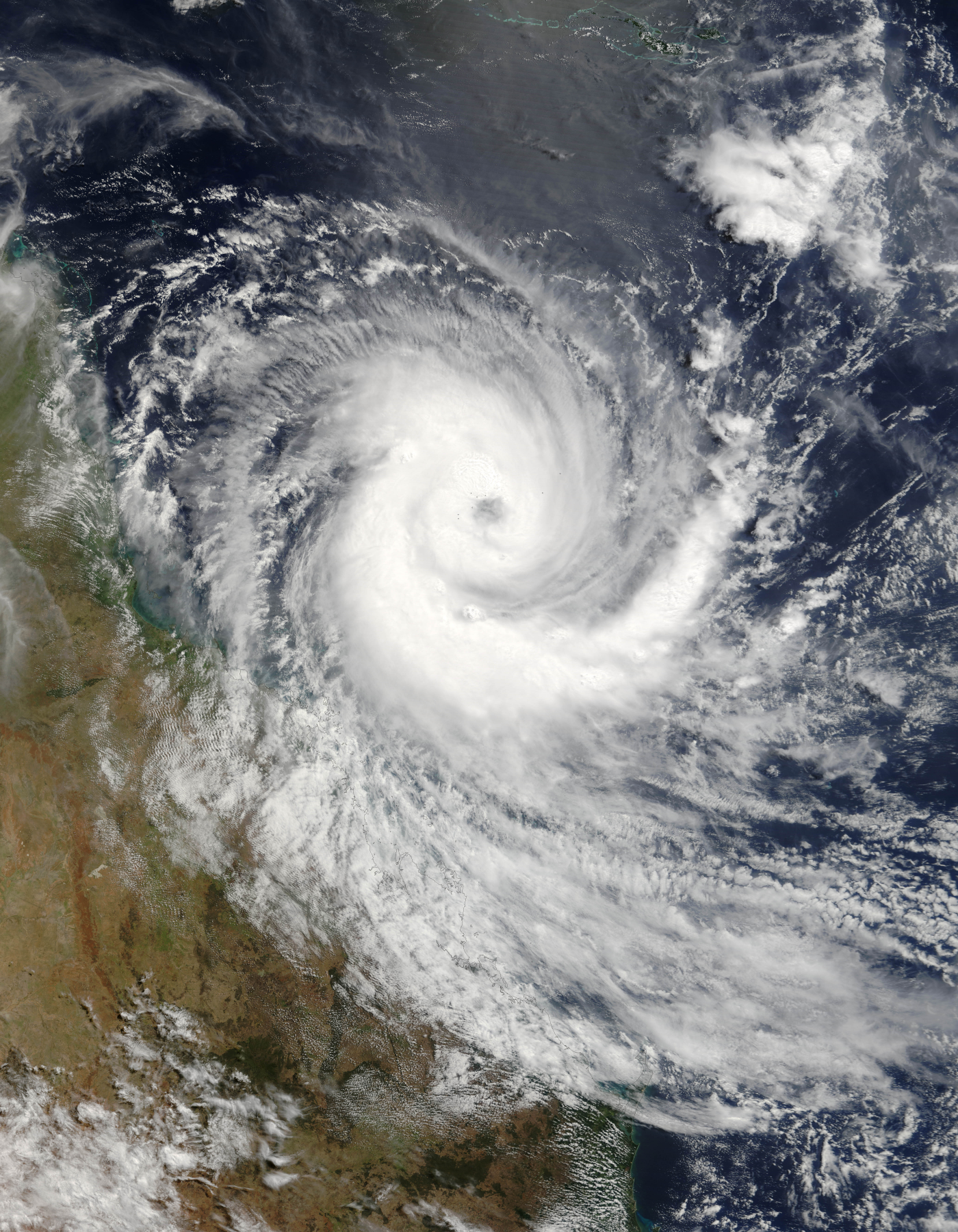 NASA AQUA MODIS true-colour satellite image of Cyclone Larry as a massive spiral cyclone approaching the Queensland coast on 19 March 2006 — the coastline is visible to the left of the storm