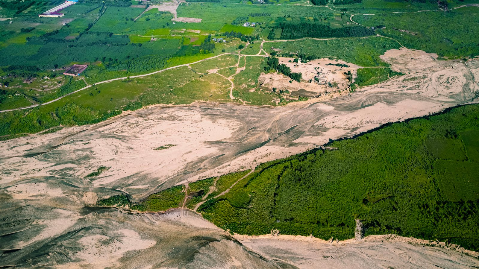 Aerial view suggesting polluted mining landscapes beside forest