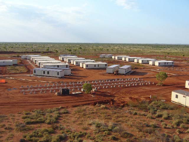 A mine work camp before Cyclone George. Rows of small huts in the red Pilbara dirt.